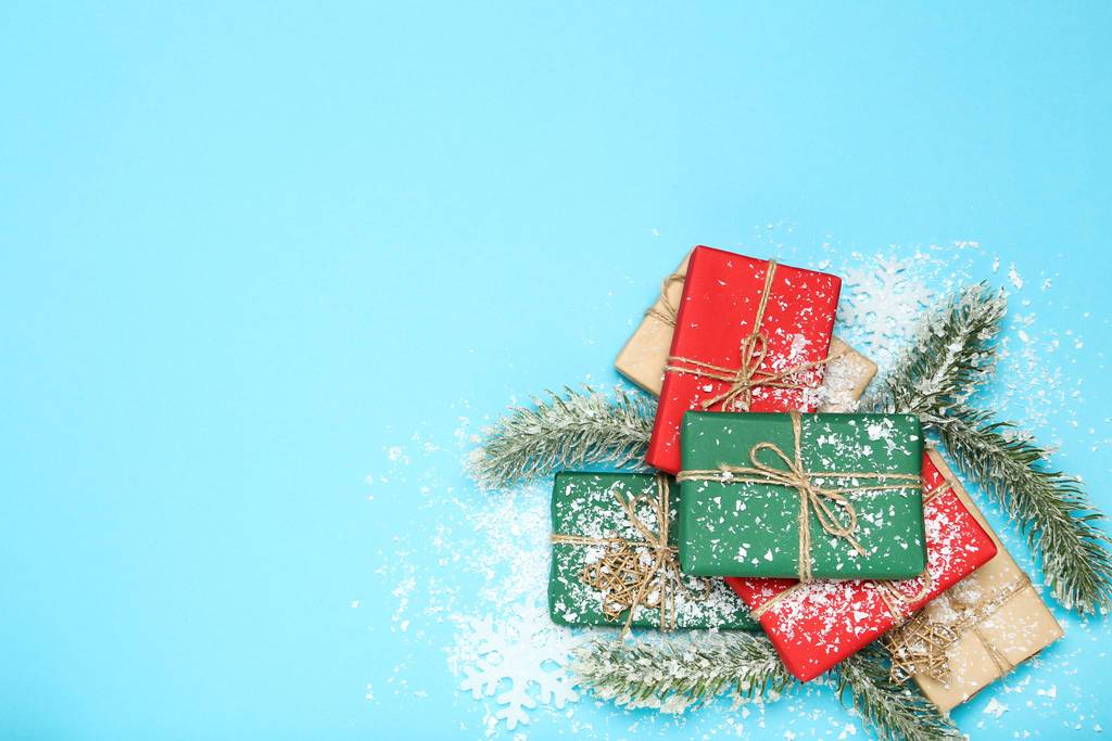 Geschenkboxen mit Tannenzweigen auf blauem Hintergrund - Foto, Bild