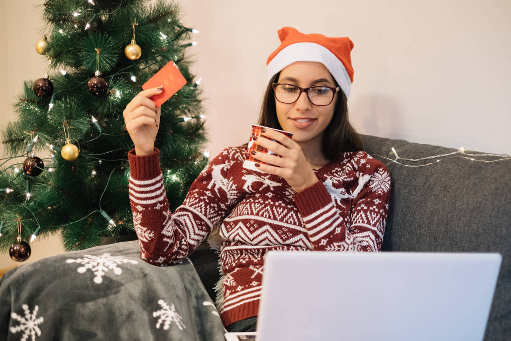 Mujer joven cerca del árbol de Navidad listo para comprar en línea
 - Foto, Imagen