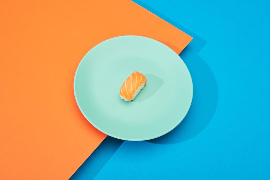 свежий нигири с лососем на голубой и оранжевой поверхности
 - Фото, изображение