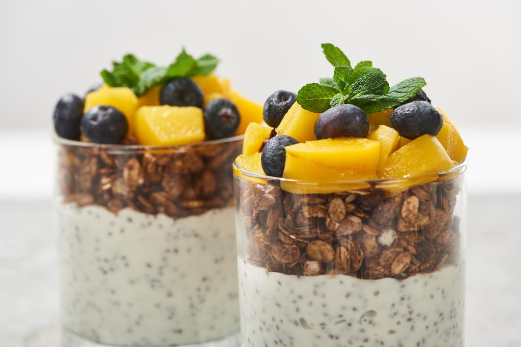 close up view of tasty granola with canned peach, blueberries and yogurt with chia seeds - Photo, Image