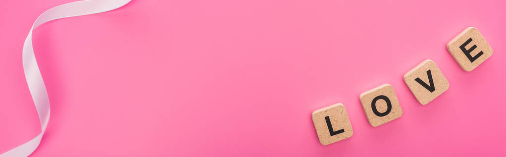 vista superior de fita e amor lettering em cubos de madeira isolados em rosa, tiro panorâmico
 - Foto, Imagem