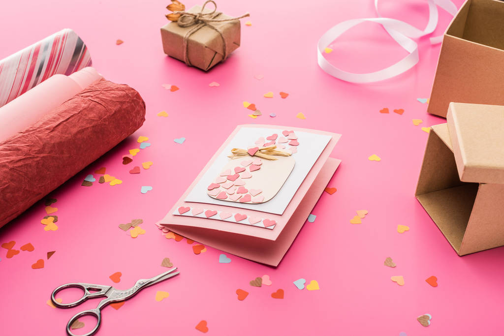 confettis de Saint-Valentin, ciseaux, carte de voeux, papier d'emballage, boîte cadeau sur fond rose
 - Photo, image