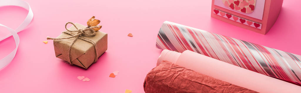 Valentine confetti, papel de embrulho, caixa de presente sobre fundo rosa, tiro panorâmico
 - Foto, Imagem