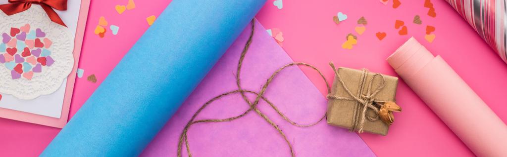 top view of valentines decoration, wrapping paper, twine, gift box, greeting card on pink background, panoramic shot - Photo, Image