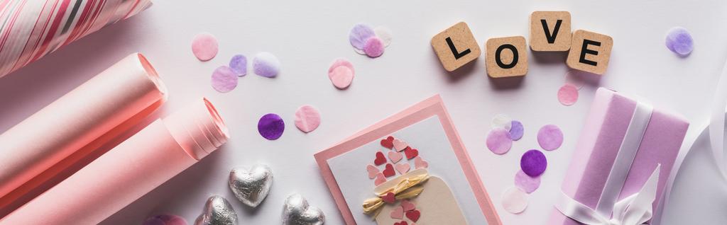 vrchní pohled na valentinky dekorace, dárky a kostky s láskou písmo na bílém pozadí, panoramatický záběr - Fotografie, Obrázek