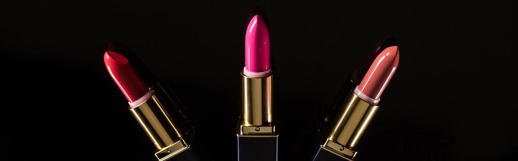 Draufsicht auf verschiedene Lippenstifte in Luxusröhrchen isoliert auf schwarzem, panoramischem Foto - Foto, Bild
