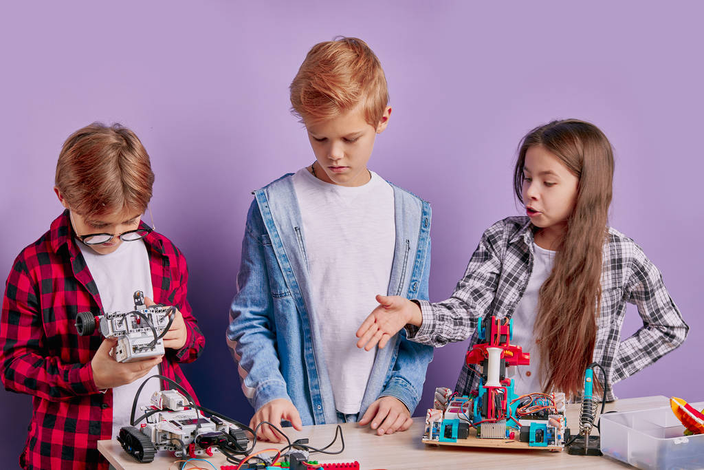 entusiastas niños preocupados ensamblando robots tecnológicos, futuros ingenieros
 - Foto, imagen
