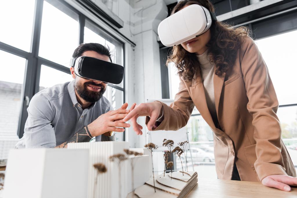 arquitectos de realidad virtual en auriculares de realidad virtual apuntando con el dedo al modelo de casa
   - Foto, Imagen