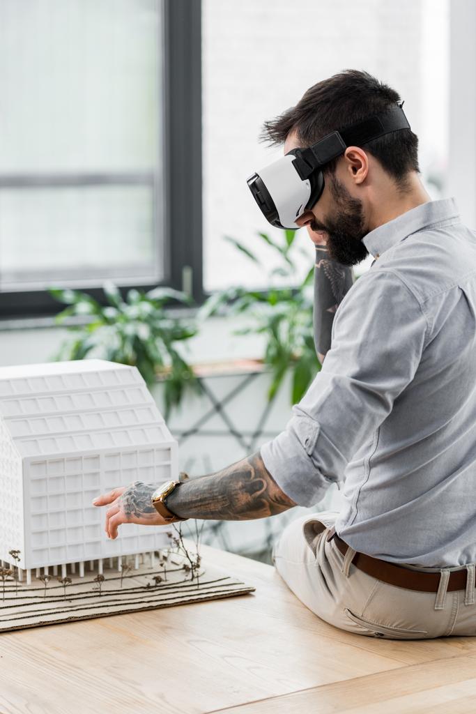 αρχιτέκτονας εικονικής πραγματικότητας στην εικονική πραγματικότητα ακουστικά κοιτάζοντας το μοντέλο του σπιτιού  - Φωτογραφία, εικόνα