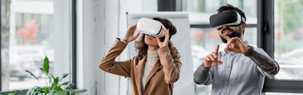 prise de vue panoramique d'architectes souriants de réalité virtuelle dans des casques de réalité virtuelle pointant du doigt
  - Photo, image