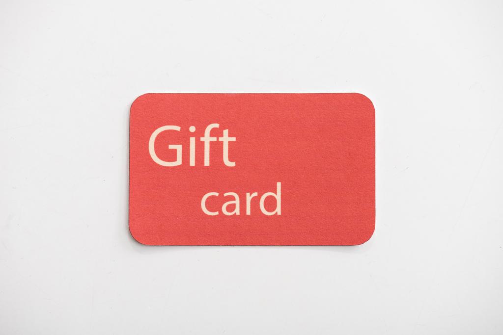 Draufsicht auf rote Geschenkkarte auf weißer Oberfläche - Foto, Bild