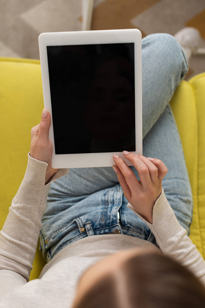 Visão aérea da menina usando tablet digital com tela em branco no sofá
 - Foto, Imagem