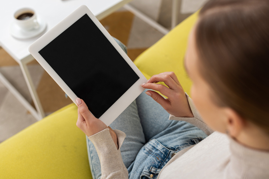Vista aérea de la mujer utilizando tableta digital con pantalla en blanco en el sofá
 - Foto, Imagen