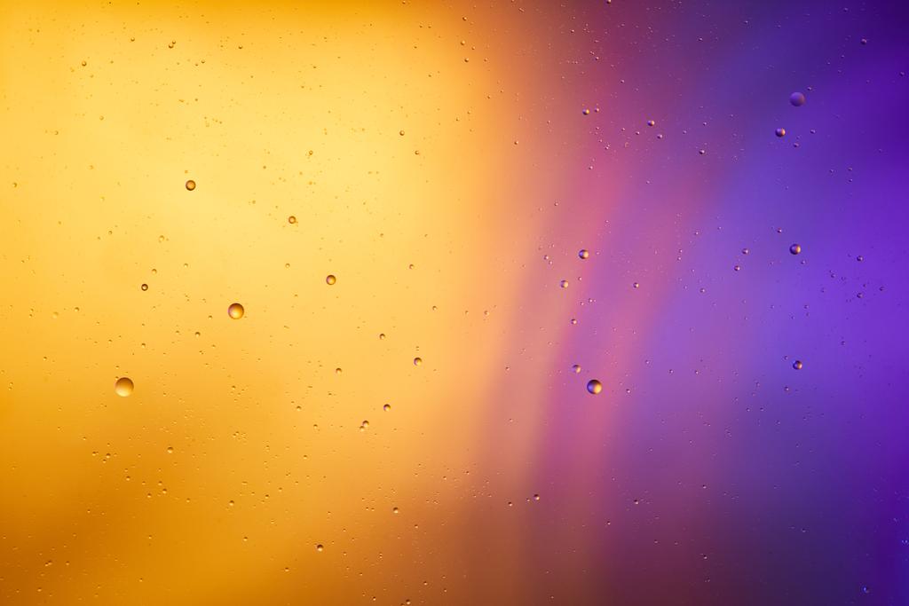 混合水と油からの抽象的なオレンジと紫色の背景 - 写真・画像