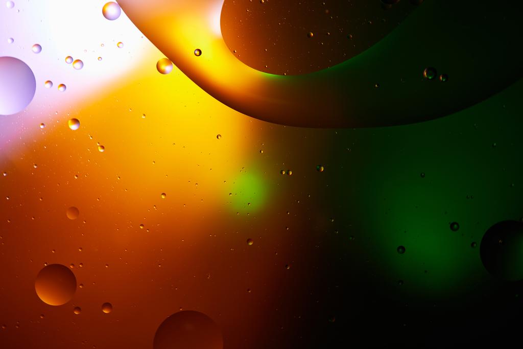 Beautiful abstract background from mixed water and oil in orange, green and purple color - Photo, Image