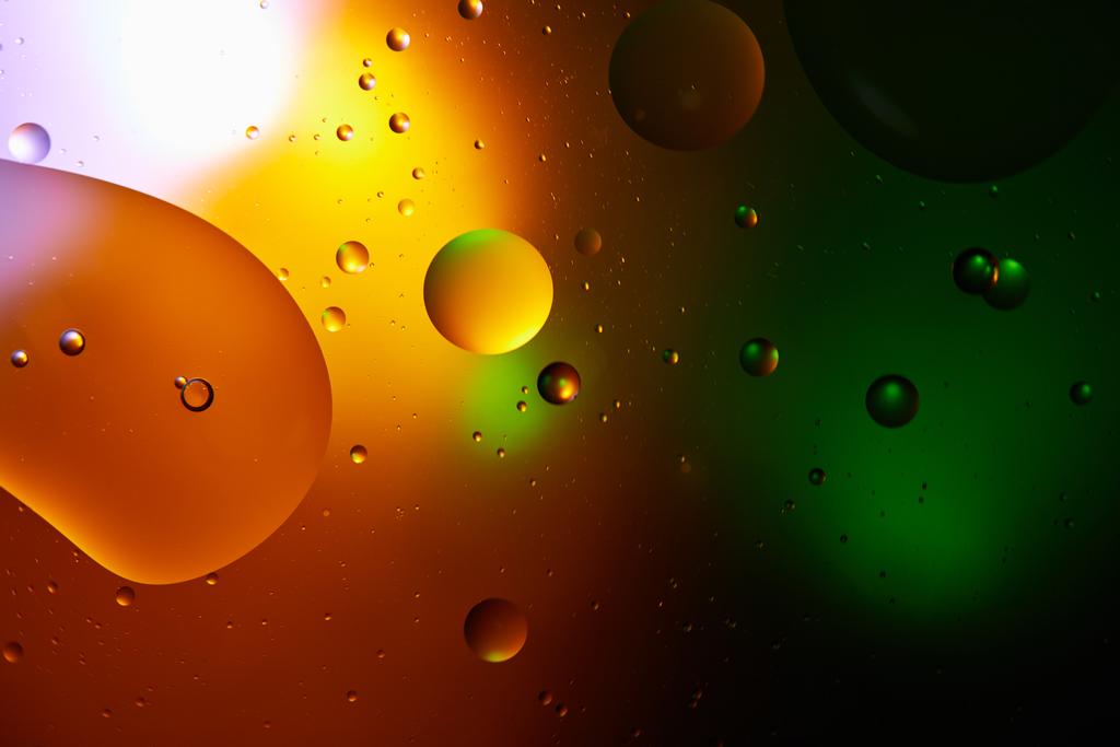 Mooie abstracte achtergrond van gemengd water en olie in oranje en groen  - Foto, afbeelding