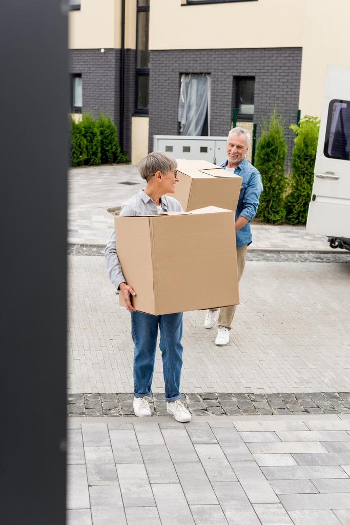 uomo maturo e donna sorridente che porta scatole a nuova casa
  - Foto, immagini