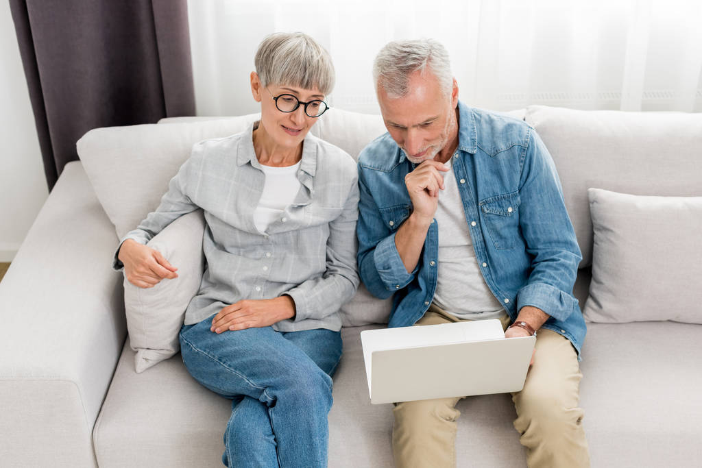 maduro homem e mulher olhando para laptop em nova casa
  - Foto, Imagem