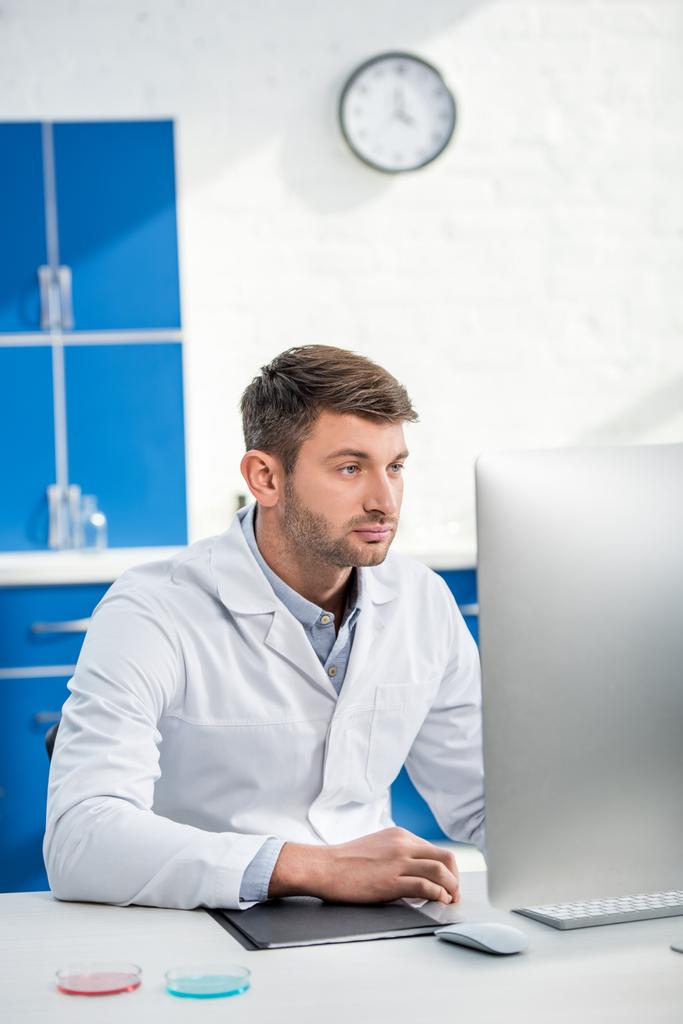 molecular nutritionist sitting at table and using computer in lab  - Photo, Image