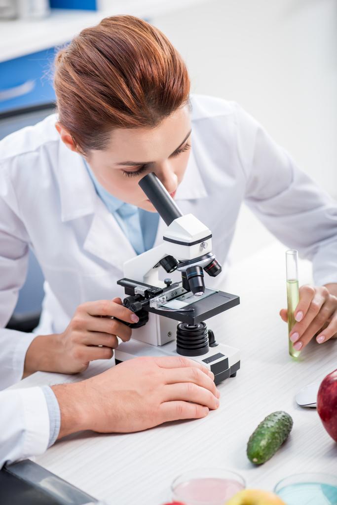 nutricionista molecular en capa blanca usando microscopio en laboratorio
  - Foto, Imagen