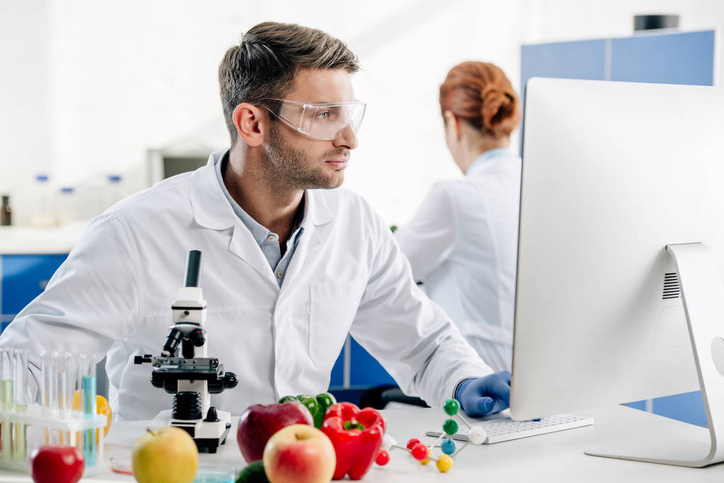 molekuláris táplálkozási szakértő fehér köpenyben számítógéppel a laborban  - Fotó, kép