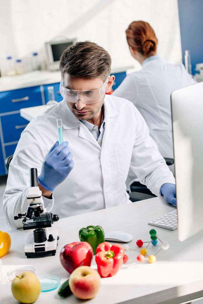 nutritionniste moléculaire dans les lunettes de protection regardant les éprouvettes en laboratoire
  - Photo, image