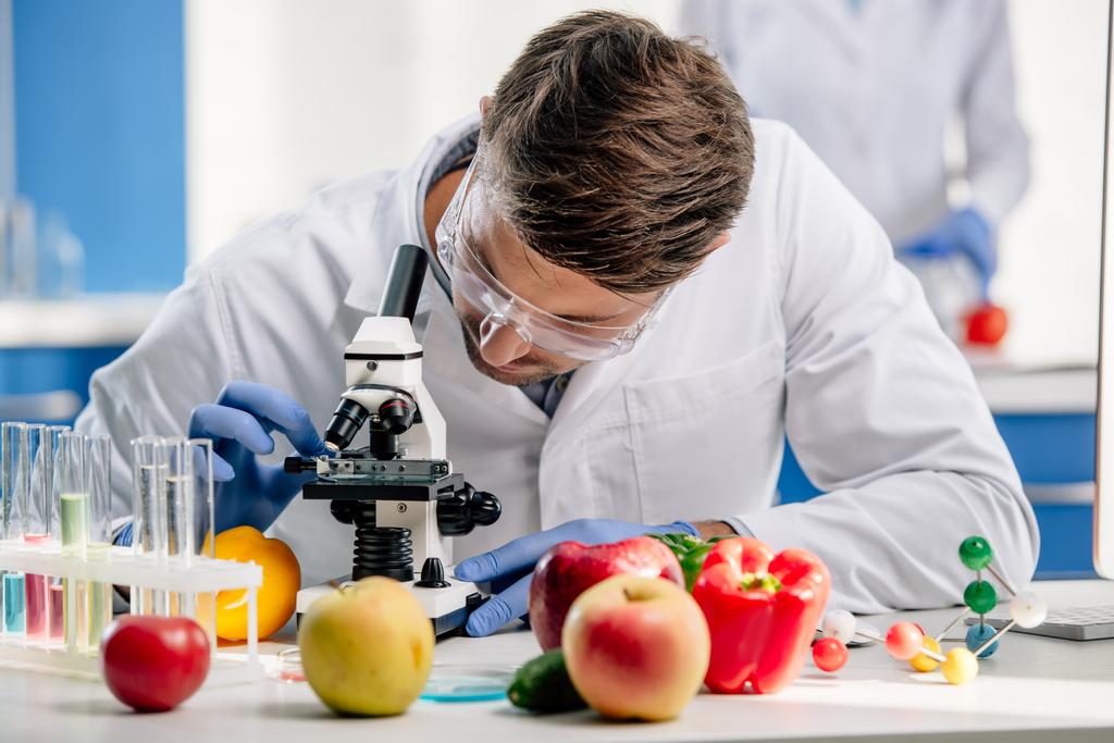 molecular nutritionist in white coat using microscope in lab  - Photo, Image