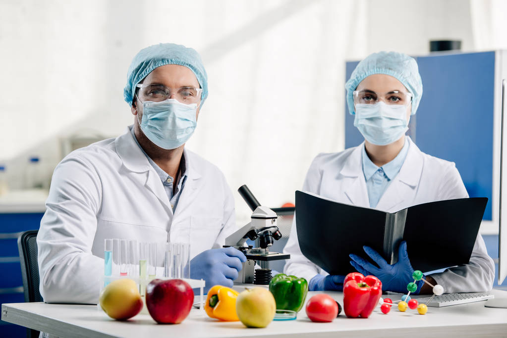 molecular nutritionists in medical masks looking at camera in laboratory - Photo, Image