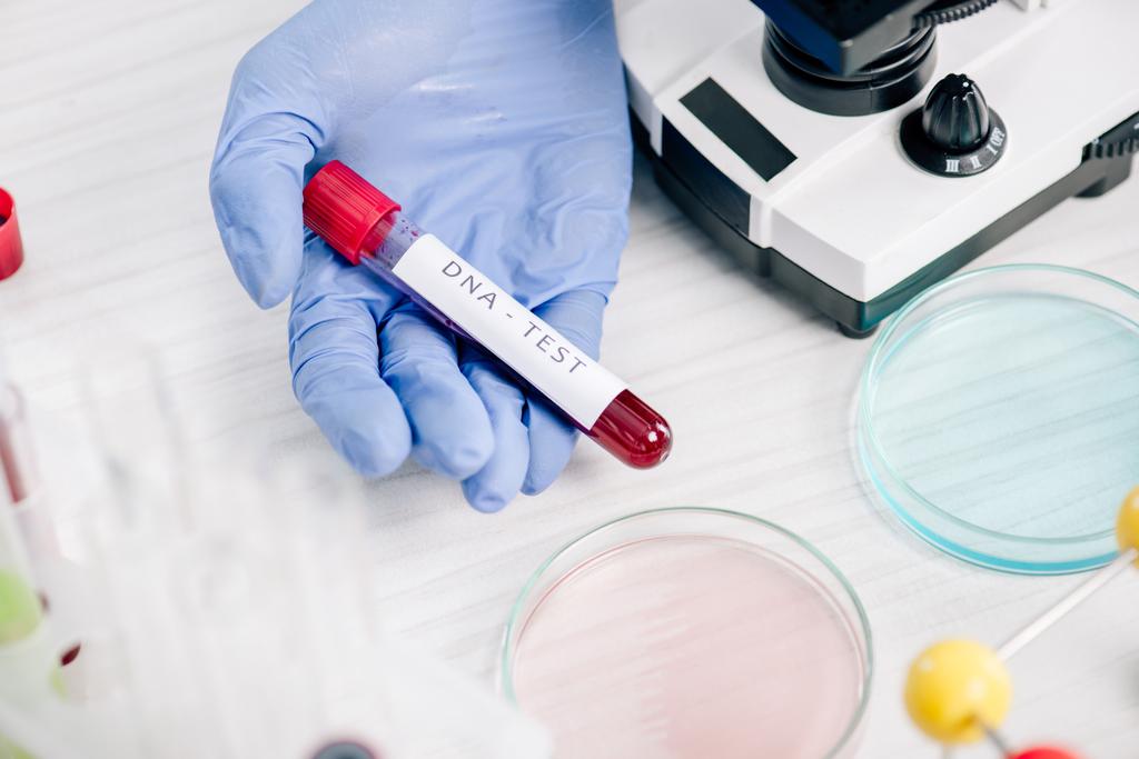 обрезанный взгляд генетического консультанта, держащего пробирку с надписью ДНК-теста
  - Фото, изображение