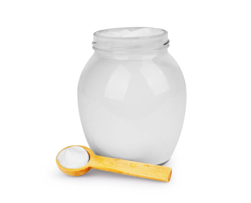 Nata azeda em um jarro de vidro com uma colher em um fundo branco
 - Foto, Imagem