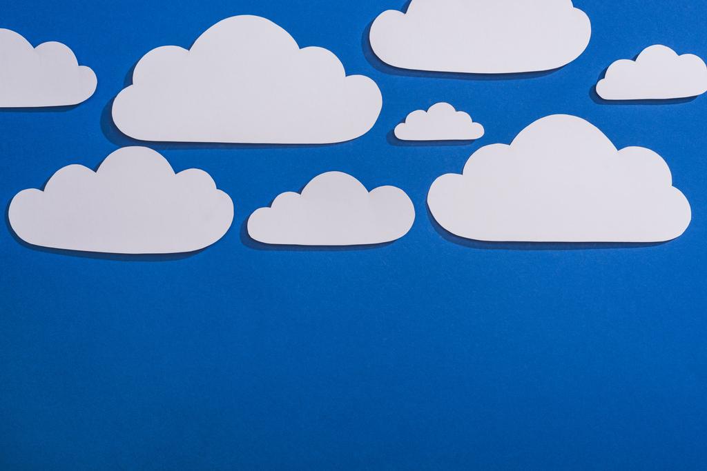 vista superior do papel branco cortar nuvens no fundo azul
 - Foto, Imagem