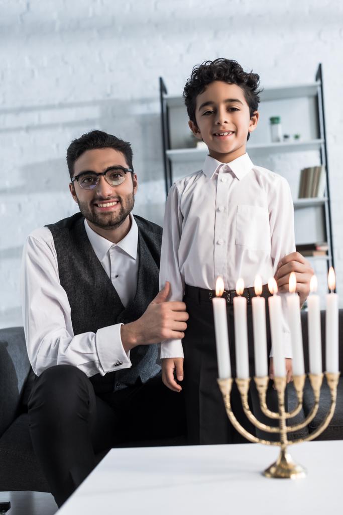 Gülümseyen Yahudi baba ve oğul dairede kameraya bakıyor.  - Fotoğraf, Görsel