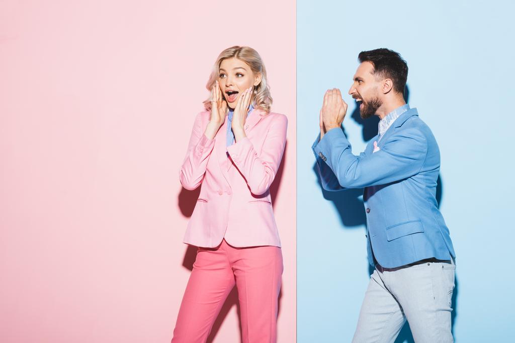hombre guapo mirando a la mujer conmocionada sobre fondo rosa y azul
  - Foto, Imagen