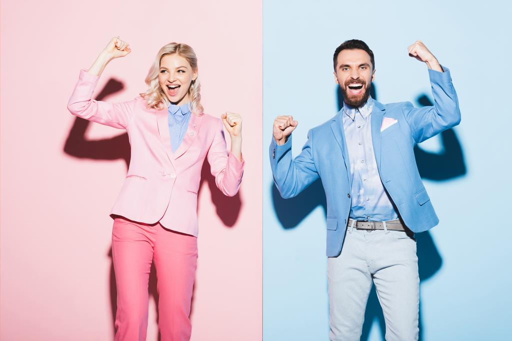笑顔の女性とハンサムな男はピンクと青の背景ではいジェスチャーを示しています  - 写真・画像