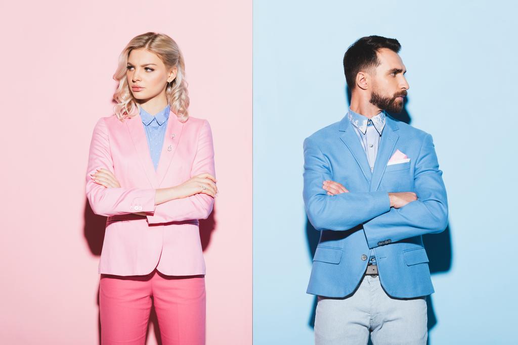 sad woman and handsome man with crossed arms on pink and blue background  - Photo, Image