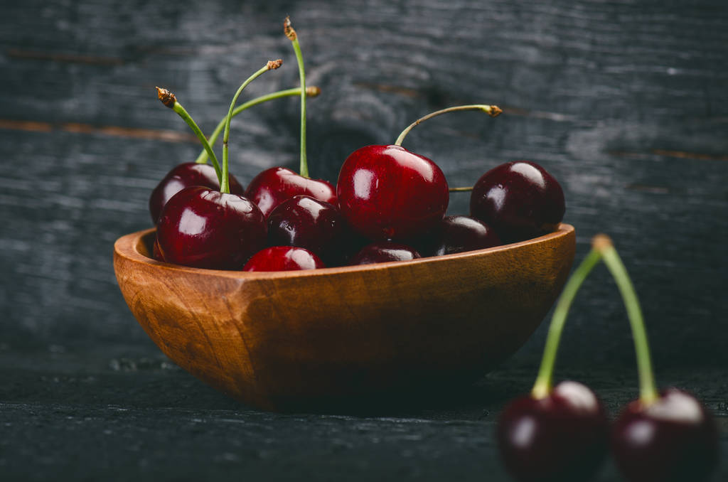 Cherries on a black table.. Natural wooden burnt table. Fresh food concept. Fruit. Summer time - Photo, Image