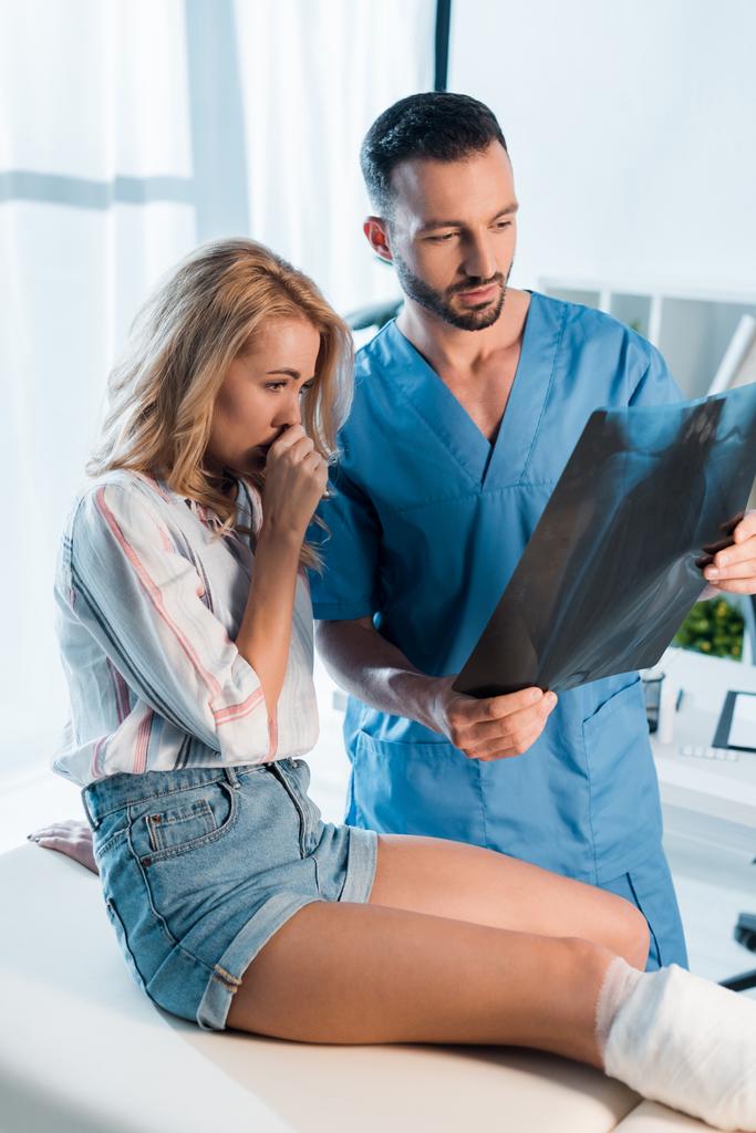 handsome orthopedist and upset woman looking at x-ray  - Photo, Image