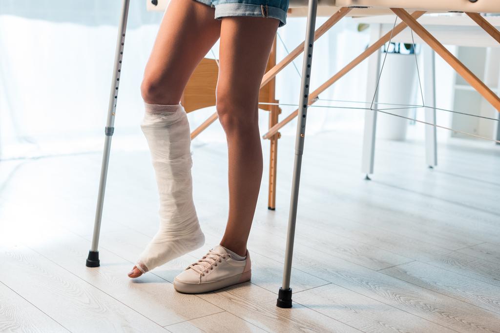 vista recortada de la mujer fracturada usando muletas para estar en la clínica
  - Foto, imagen