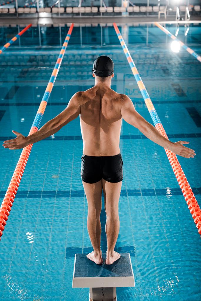 takaisin näkymä uimari seisoo ojennetut kädet lähellä uima-allas
  - Valokuva, kuva