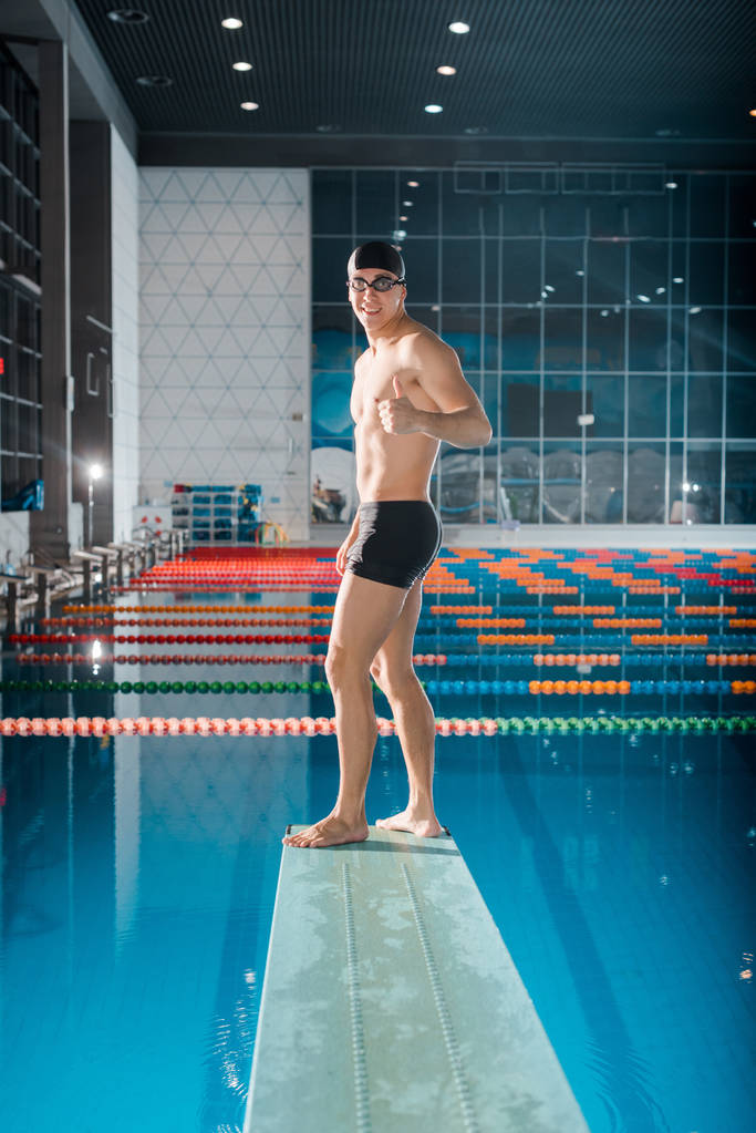 nadador feliz mostrando polegar para cima enquanto está de pé na placa de mergulho
  - Foto, Imagem