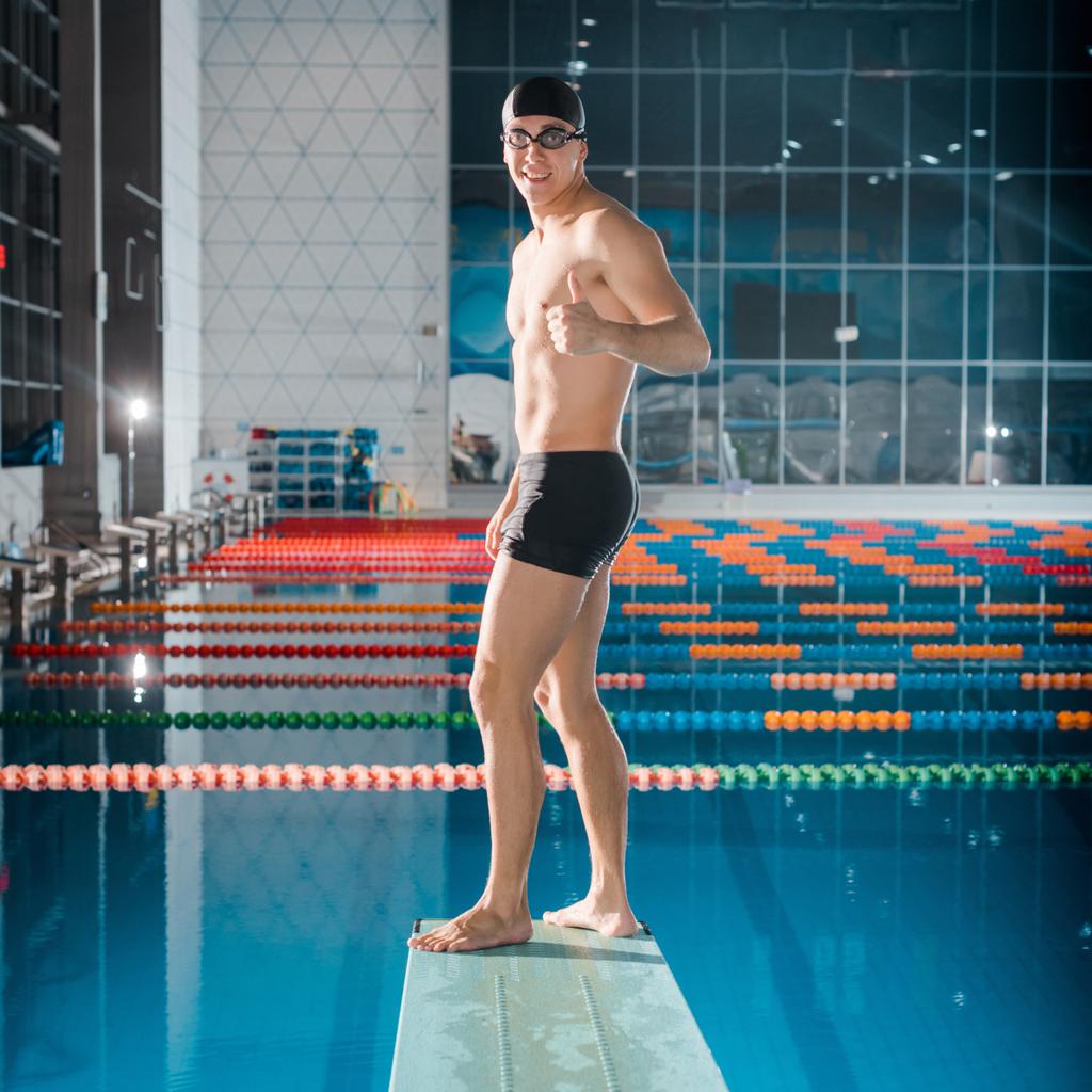 nadador sorrindo mostrando o polegar para cima enquanto está de pé na prancha de mergulho
  - Foto, Imagem