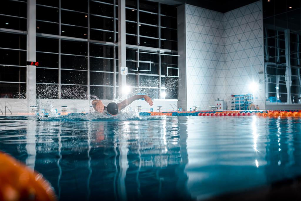スイミングプールでのスポーツマン水泳蝶ストロークの選択的な焦点  - 写真・画像