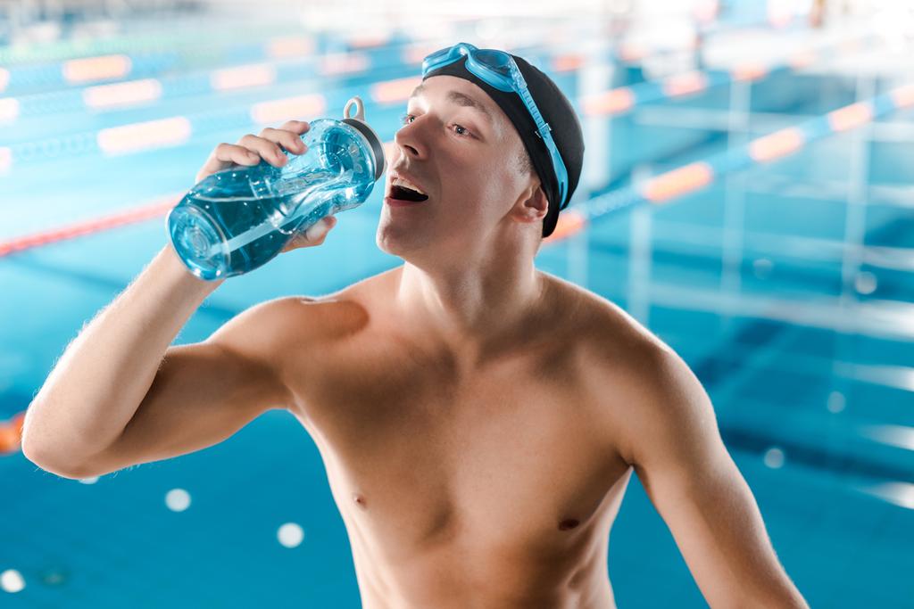 hezký plavec pití ze sportovní láhve  - Fotografie, Obrázek