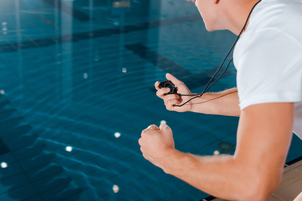 levágott kilátás atlétikai edző időzítővel medence mellett  - Fotó, kép