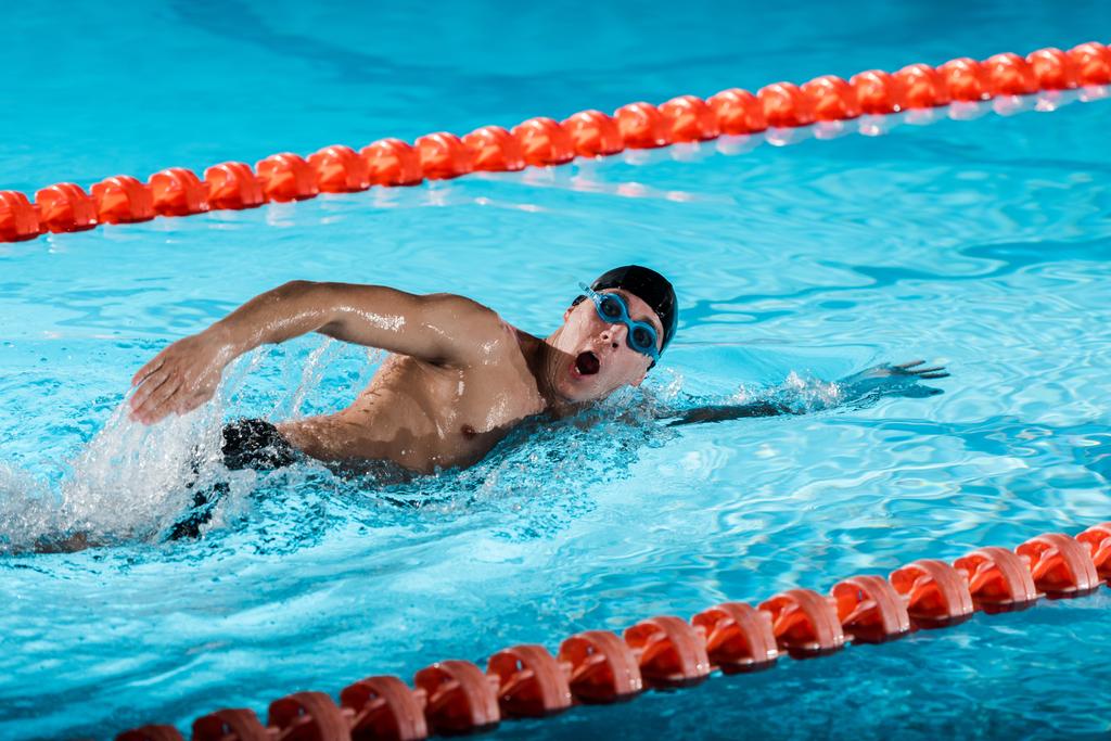 gocce d'acqua vicino al nuotatore con allenamento a bocca aperta in piscina
  - Foto, immagini