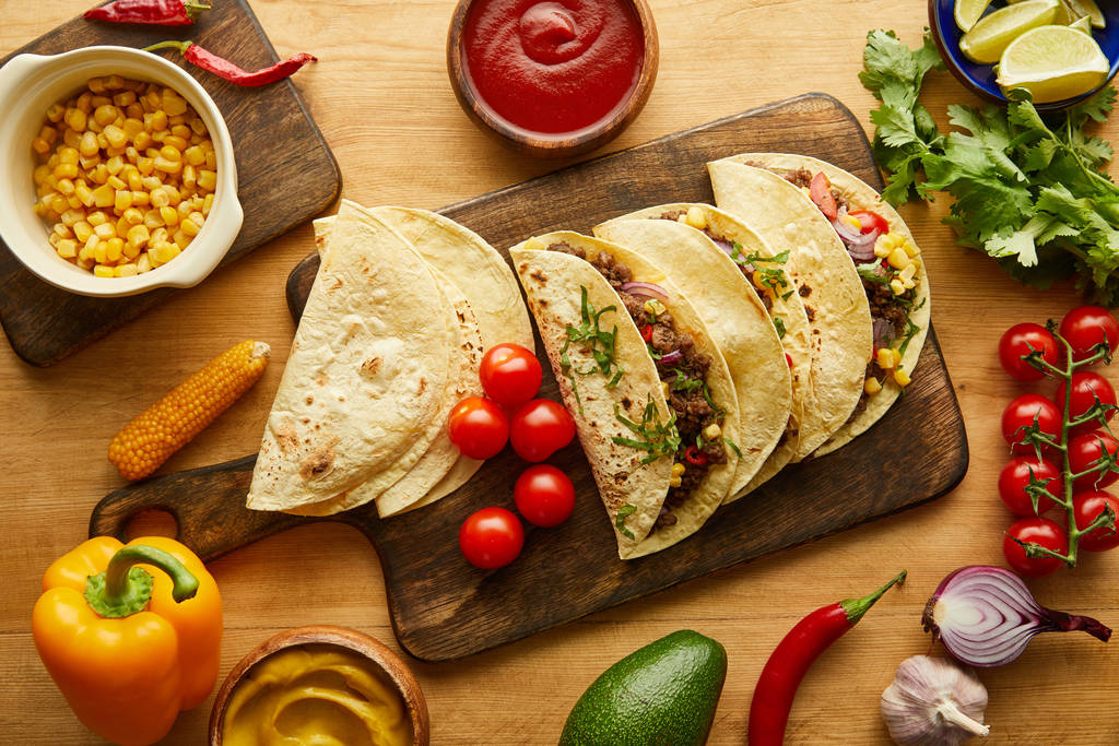 Tahta masada taze malzemeler ve etli taco manzarası. - Fotoğraf, Görsel