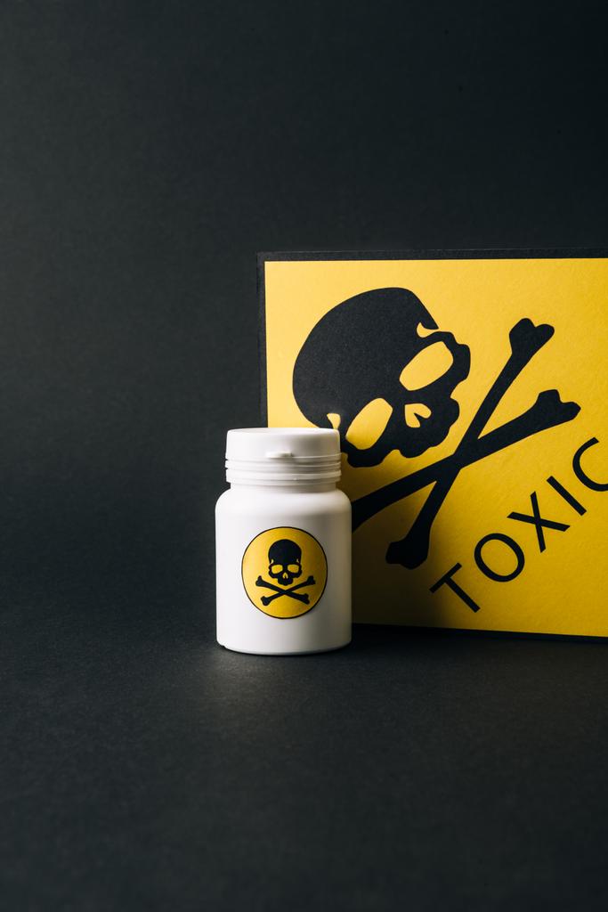 Jar and yellow toxic sign isolated on black - Photo, Image