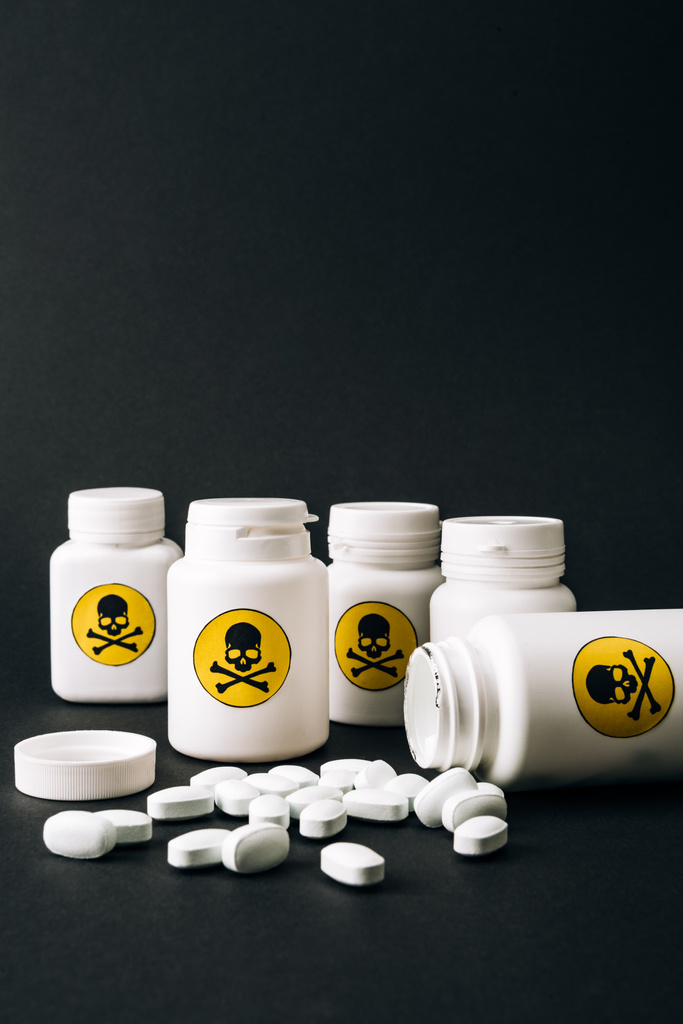Пляшки зі знаком отрути і таблетки ізольовані на чорному
 - Фото, зображення