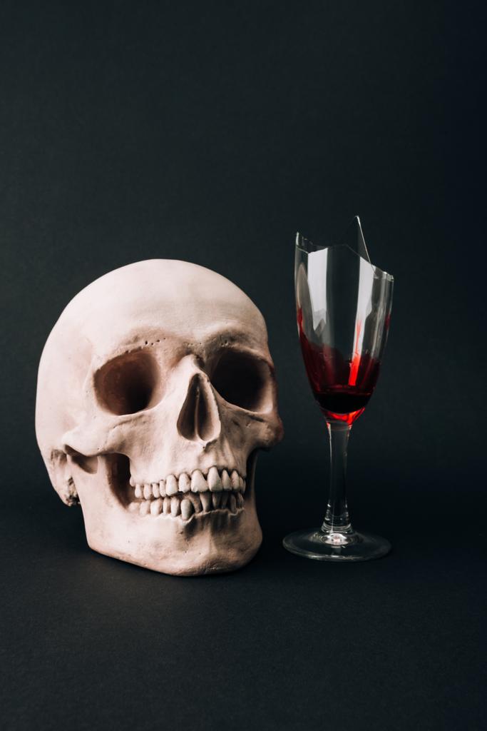 Cráneo y cristales rotos con sangre aislada en negro
 - Foto, Imagen