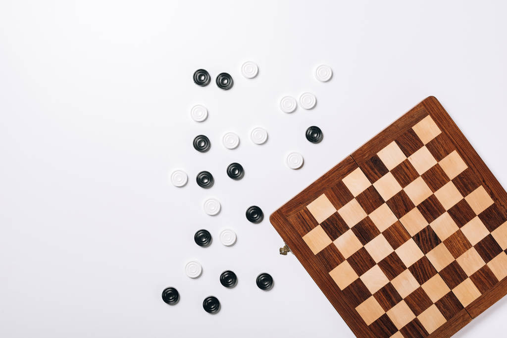 Top view of checkers and chessboard on white background - Photo, Image
